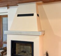 Fireplace in a cabin with a wooden ceiling and stone cladding.