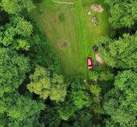 A cottage in the Šugov Valley, Medzev, surrounded by forest and a large green garden.