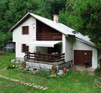A cottage in nature in the Šugovská Valley in Medzev surrounded by trees and greenery.