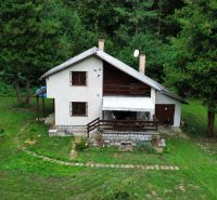 A cottage in the Šugov Valley in Medzev, surrounded by greenery and trees, in a peaceful environment.