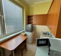 Kitchen in the office with a microwave, table, and fridge.