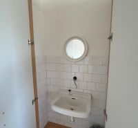 Bathroom with a mirror, sink, and floor with wood decor.
