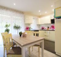 A kitchen in a family house with a dining table, chairs, and a wooden decor floor.