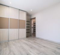 Interior of a family house with a wooden decor floor and a built-in wardrobe.