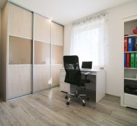 Interior of a family house with a wooden decor floor, a desk, and a wardrobe.