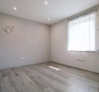 A bright room in a family house with a wooden decor floor and a curtain.