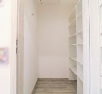 Storage space with shelves and a wooden decor floor in a family house.
