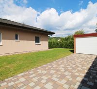 A family house in Bytča with a garden and a garage on a paved area.