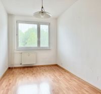 A room in a 2-room apartment with a wooden decor floor and a large window.