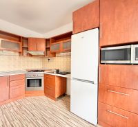 A kitchen in a 2-room apartment with a wooden decor, a stove, and a microwave.