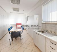 A kitchenette in the production area with a dining table and storage cabinets.