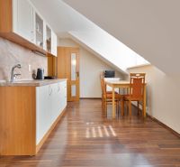 A kitchen with a slope, a dining table, and a wooden decor floor in a 2-room apartment.