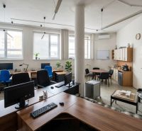 Offices with computers and furniture in a spacious interior with a wooden decor floor.