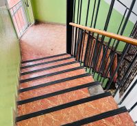 A staircase with a wooden railing and a tiled floor in the offices.