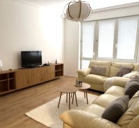 Living room in a three-room apartment with a beige sofa and a wooden decor floor.