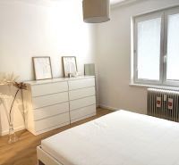 Bedroom with a dresser, bed, and wooden decor flooring in a 3-room apartment.