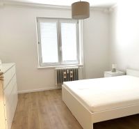 A bedroom in a 3-room apartment with a wooden decor floor and a window with blinds.