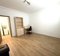 A room in a 3-room apartment with a desk and a wooden decor floor.