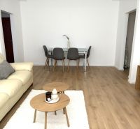 Living room in a 3-room apartment with a cream sofa and a wooden decor floor.