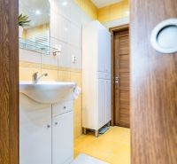 A bathroom with a sink, mirror, and cabinet in a 2-room apartment.