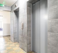 Entrance area in a building with an elevator and tiled floor.