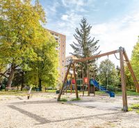A children's playground surrounded by greenery on Novomeského Street in Košice, Staré Mesto district.