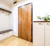 Entrance hall in a 2-room apartment with a cabinet, bench, and floor with a wooden decor.