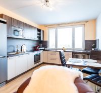A kitchen in a 2-room apartment with a wooden decor floor and modern appliances.