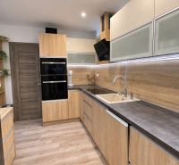 A kitchen in a 3-room apartment with a wooden decor floor and built-in appliances.