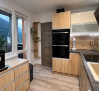 A kitchen in a 3-room apartment with a wooden decor floor and modern equipment.