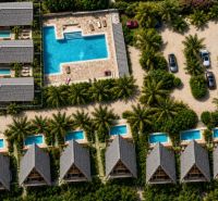 Aerial view of family houses in Pwani Mchangani with pools and palm trees.