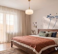 A bedroom in a 2-room apartment with a wooden decor floor and natural textiles.