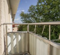 Rooftop terrace with metal railing and a view of the trees in Nova Dubnica.