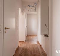 Interior of a 2-room apartment with a wooden decor floor and decorative details on the wall.