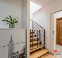 A hallway in a 3-room apartment with a decorative cabinet and a staircase with a wooden decor.