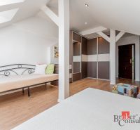 A bright room in a 3-room apartment with a wood-patterned floor, a bed, and storage space.