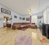 Living room in a family house with a comfortable sofa set and tiled floor.
