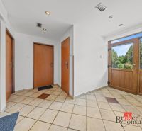 Entrance hallway of a family house with three doors and tiled floor.