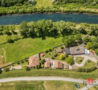 Aerial view of a family house by the river in Hamuliakovo surrounded by greenery.