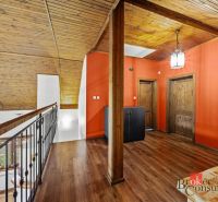 A hallway with a wooden decor floor and orange walls in a family house.