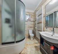 A bathroom with a bathtub, sink, and toilet with tiling in a family house.