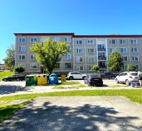 Apartment building in Stará Ľubovňa on Komenského Street with a parking lot in front of the building.
