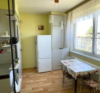 A kitchen with a wooden decor floor and a dining table in a 2-room apartment.