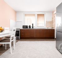 A kitchen in a 3-room apartment with a dining table and a wooden decor floor.
