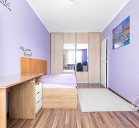 Children's room with purple walls, built-in wardrobe, and wood-patterned flooring.