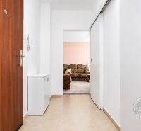 Entrance hall with light tiles and brown doors in a 3-room apartment.