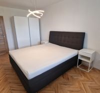 Bedroom with a double bed, white wardrobe, and wooden decor flooring in a 3-room apartment.