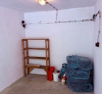 The interior of a garage with a wooden shelf and stored tires.