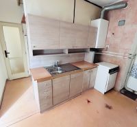 A kitchen in a 2-room apartment with a simple kitchenette and a floor with a wood decor.