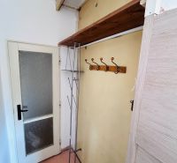 Entrance hallway in a 2-room apartment with a coat rack and a wall shelf.
